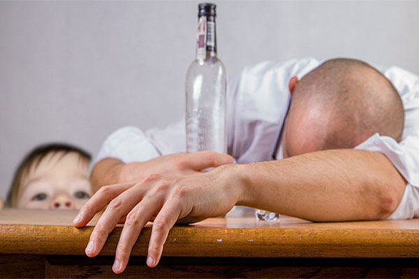 Un alcoholico es observado por su hijo pequeño. Foto: Pixabay